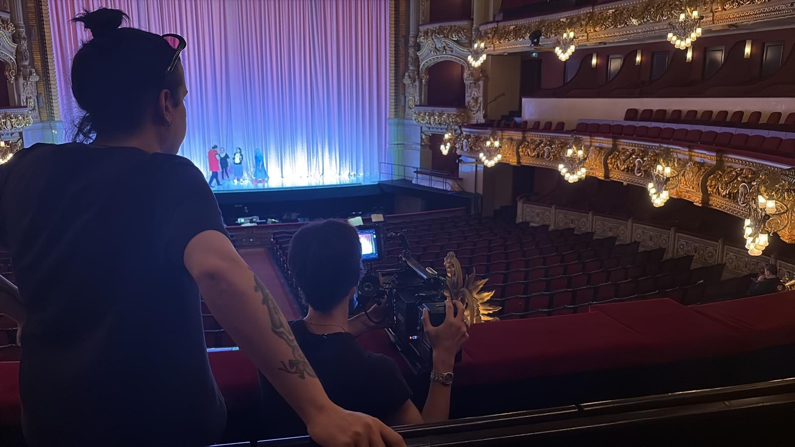 Crew filming the stage from a balcony