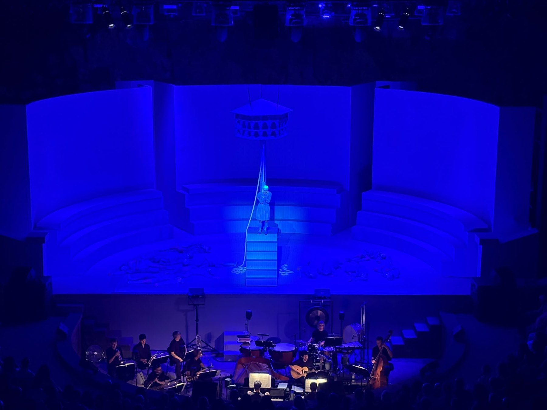 Stage bathed in blue light above a live orchestra